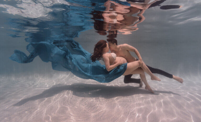 epic underwater pregnancy maternity couple with flowy dress man and woman 768x468